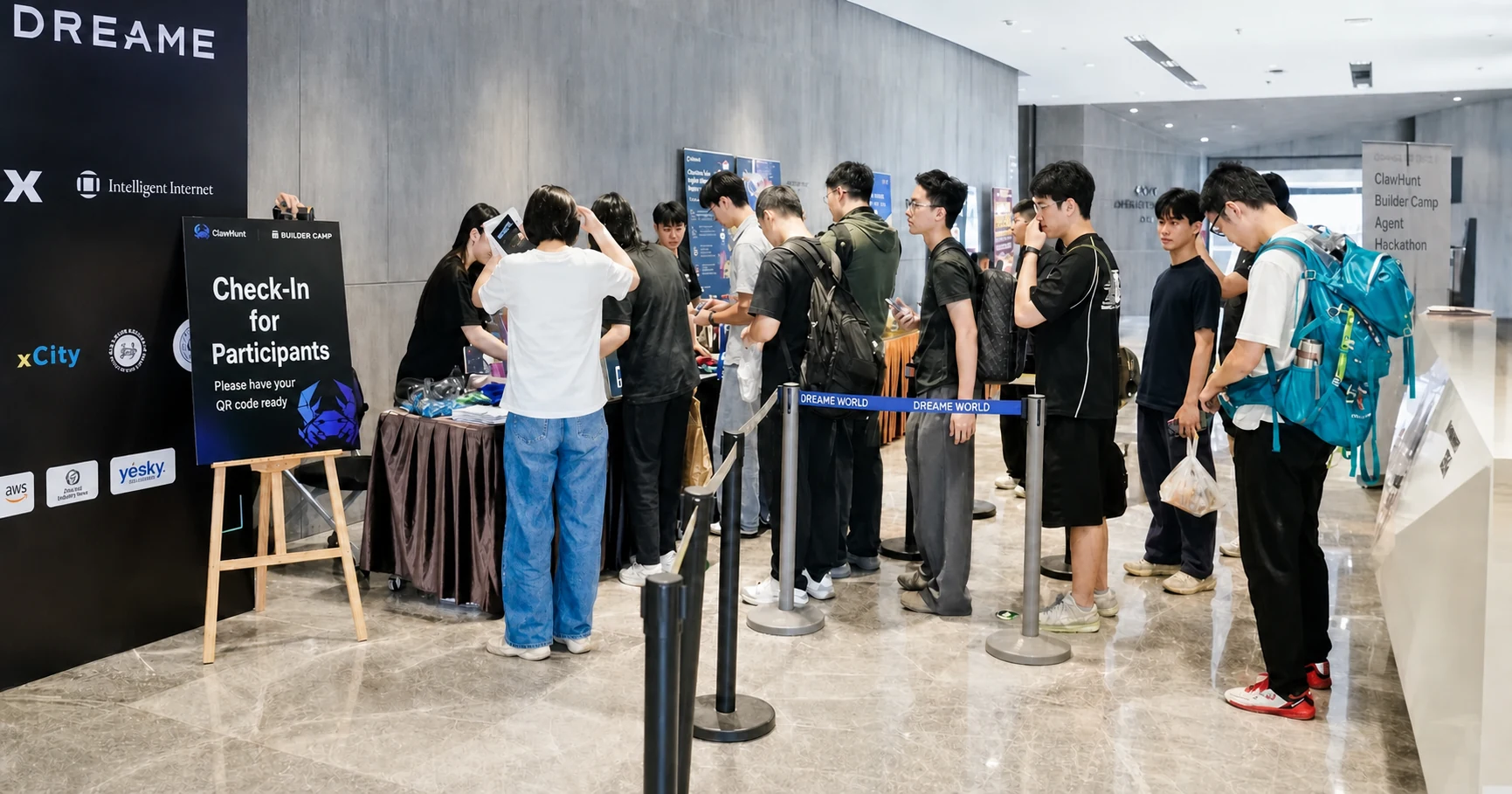 图片展示的是100 Builders全球72h百人黑客松赛事现场。画面中,多名开发者正排队在“选手签到处”前签到,签到处设有桌椅,桌上有赛事相关资料。背景墙上有“DREAM”等标识,以及“Intelligent Inno”等字样。部分开发者背着电脑包,有的手持设备,有的在交流。该图片与上文提到的开发者们提前到场、准备大干一场、积极交流等场景相契合,直观呈现了赛事现场的热闹氛围。