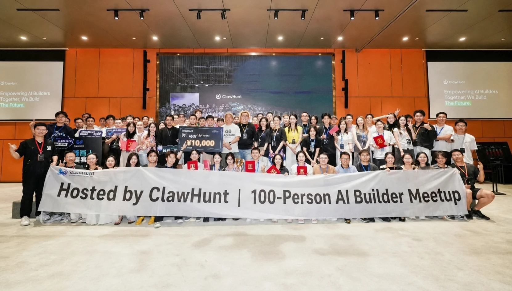 图片展示的是“ClawHunt爪寻主办 | 百人AI Builder线下盛会”的大合影。众人手持写有“ClawHunt爪寻主办 | 百人AI Builder线下盛会”字样的横幅,背景是舞台,舞台上有“ClawHunt 爪寻的人”字样,还摆放着一个写有“$10,000”的奖杯。这张图片与上文提到的“一张大合影,定格这场72小时的热血与青春”相呼应,记录了这场72小时黑客松活动的集体记忆。